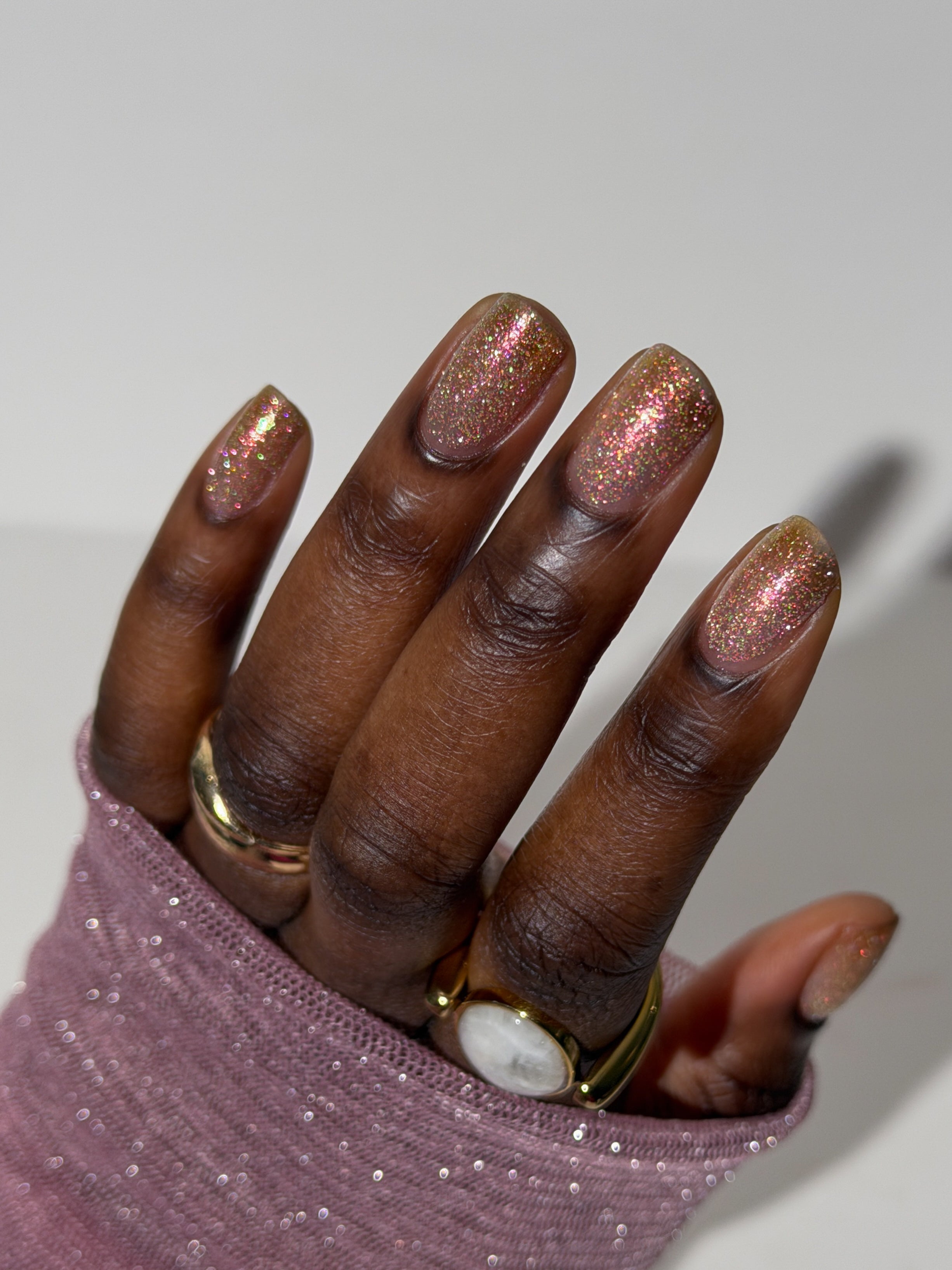 Resistance by Glitch Lacquer, sheer white with reflective glitter swatch on deep skin, oval nails