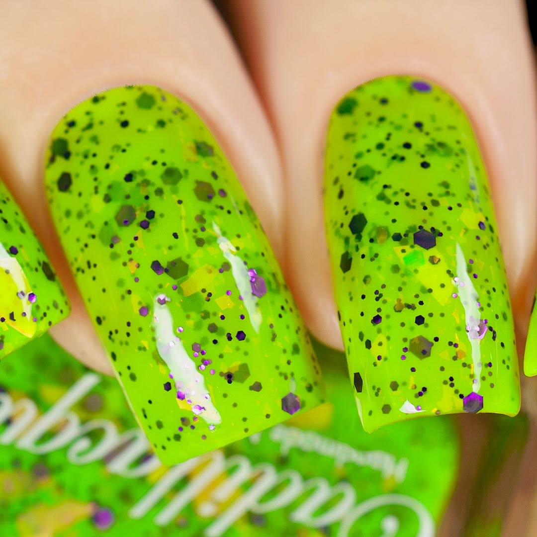 Dapper but no Dan by Cadillacquer, neon lime green glitter flakie with multi-size purple hex glitter, black microglitter, and golden yellow iridescent flakes, on a light skin tone hand