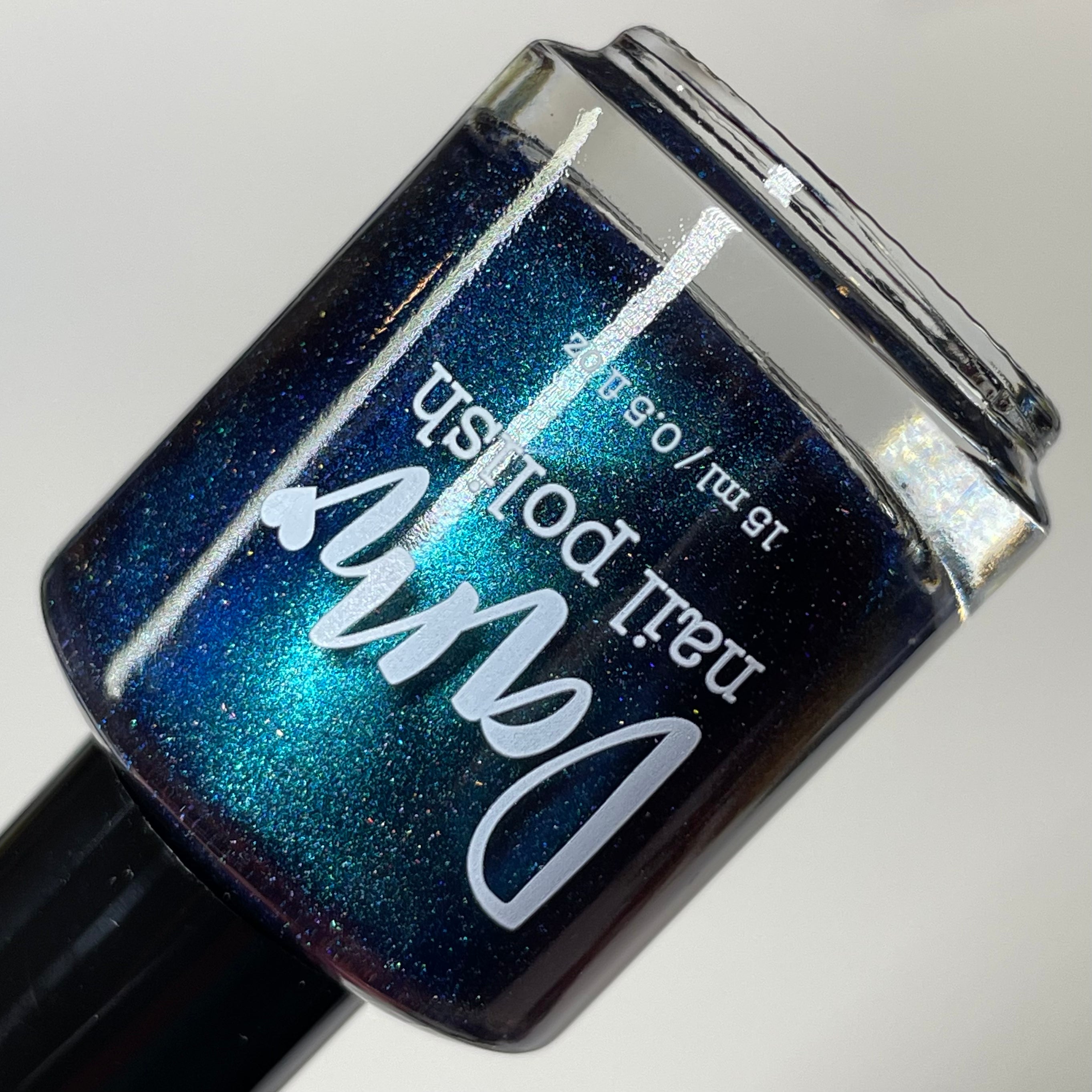 Wake Me Up Before You Cocoa by Dam Nail Polish, deep navy-purple shimmer magnetic mid-shift from teal to blue with fine microflake shimmer, bottle standalone product shot