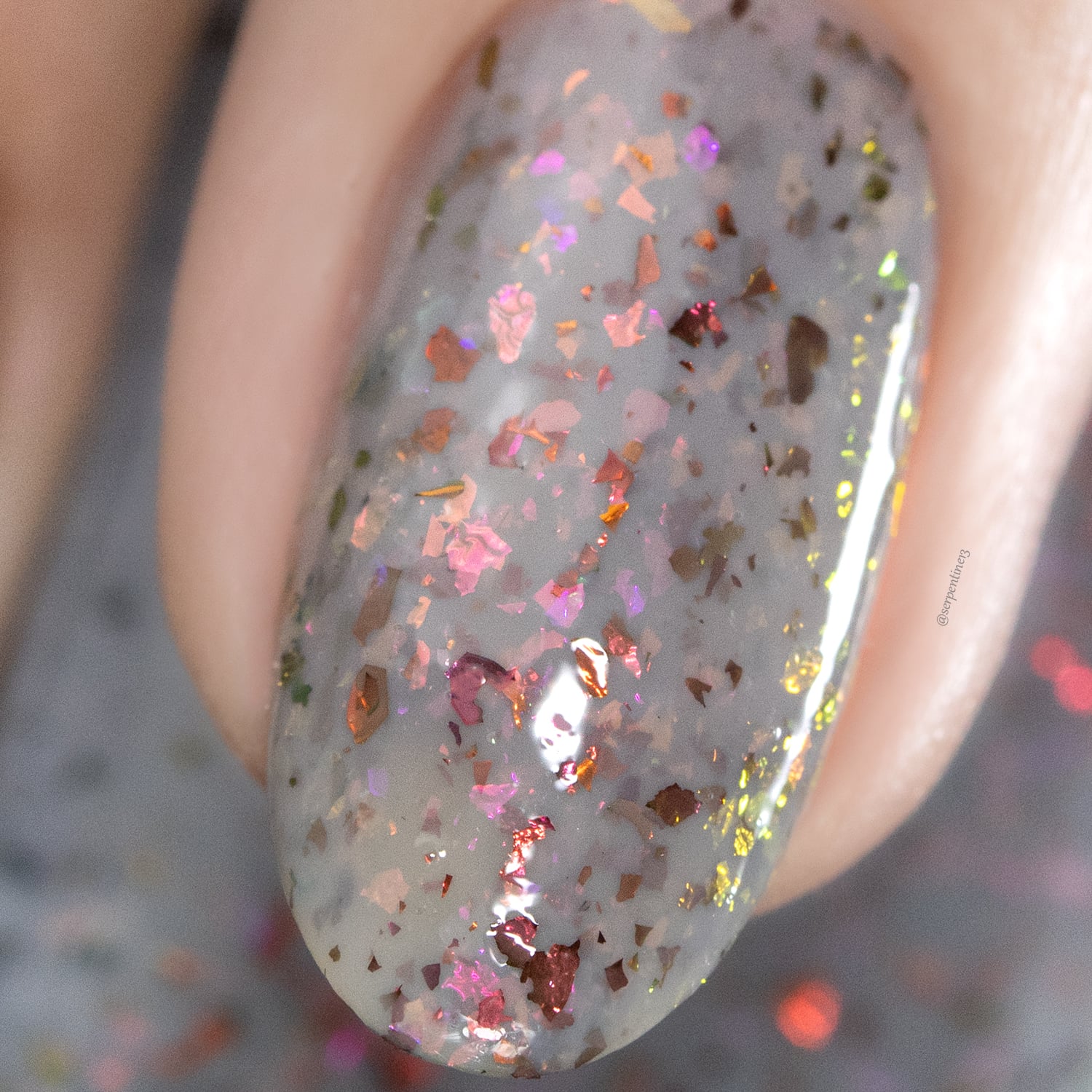 Cadillacquer Daydreaming grey red chameleon iridescent crelly nail polish, macro single-nail swatch, light skin, studio lighting
