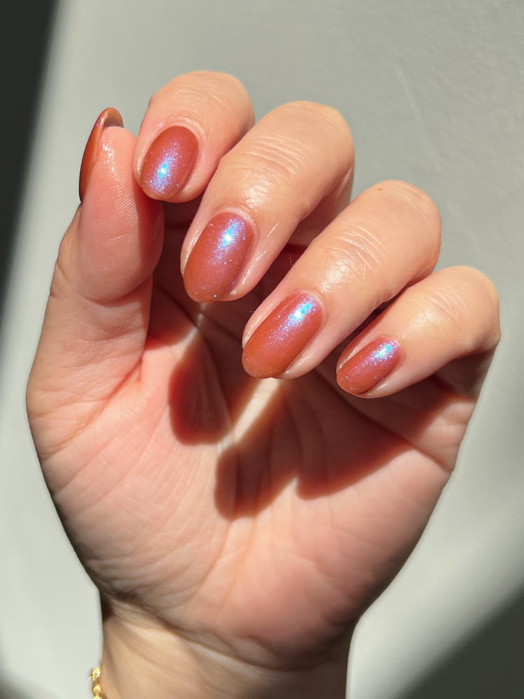 Enth E ND by Danglefoot Nail Polish, blue-brown shimmer on a light skin tone hand