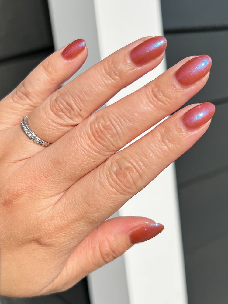 Enth E ND by Danglefoot Nail Polish, blue-brown shimmer on a light-medium skin tone hand