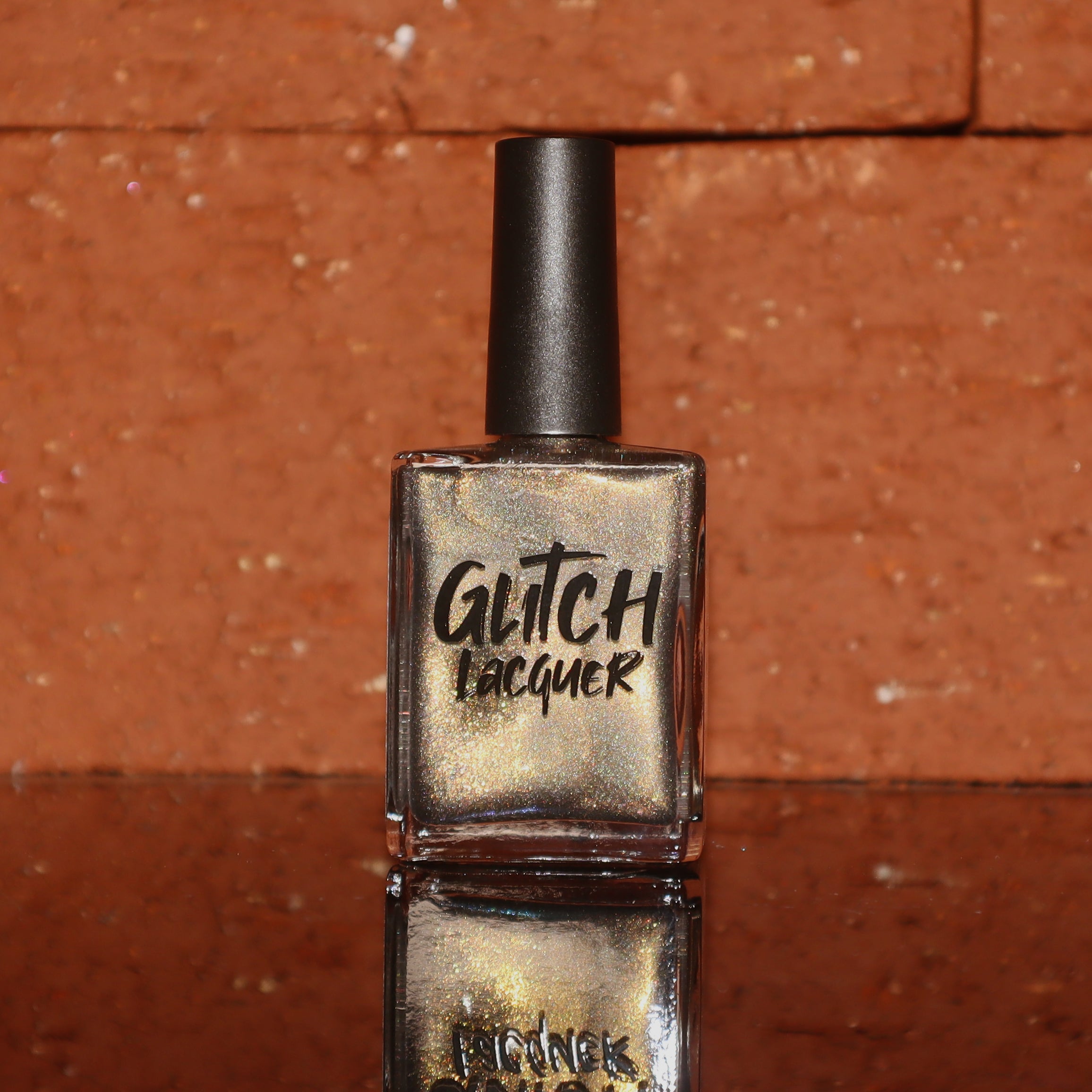 Safe House Glow by Glitch Lacquer, smokey grey base with gold-to-green-teal shift and holo shimmer, bottle