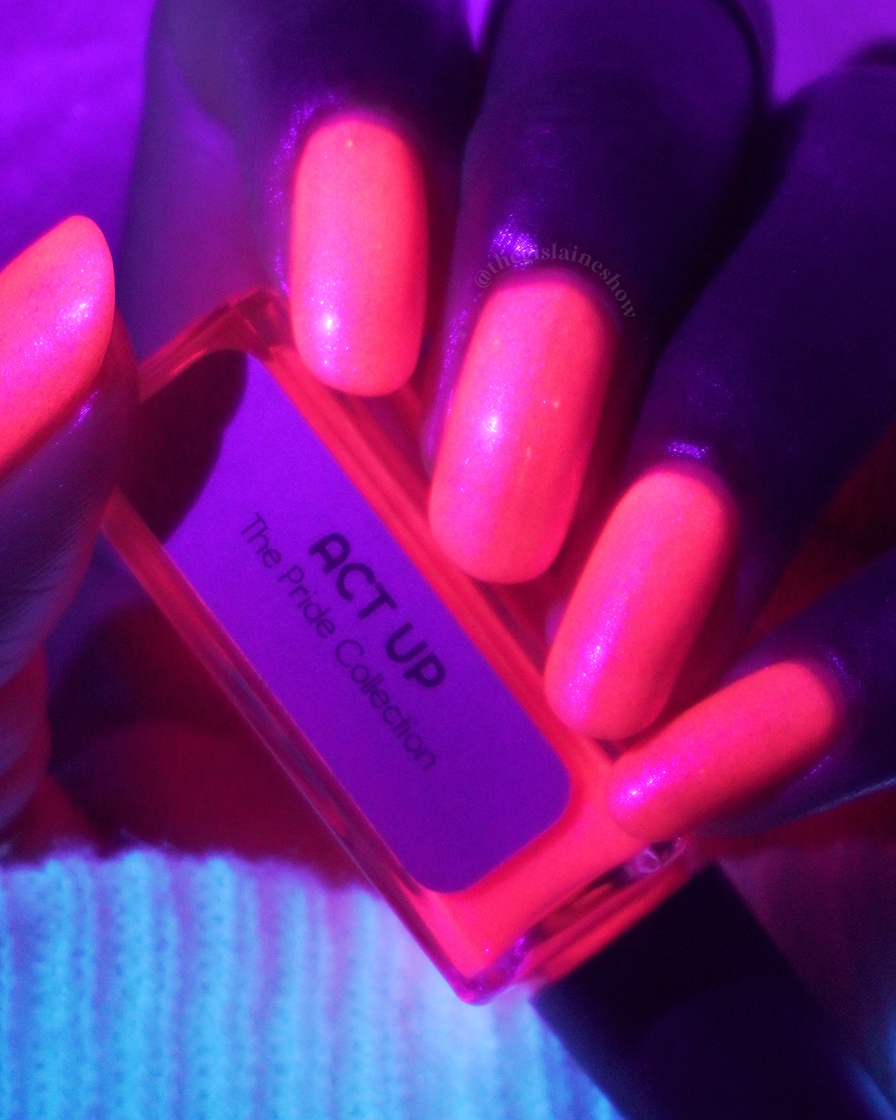 ACT UP by Glitch Lacquer, neon pink crelly with cool-toned pink sparkle, bottle in hand under blacklight on deep skin tone