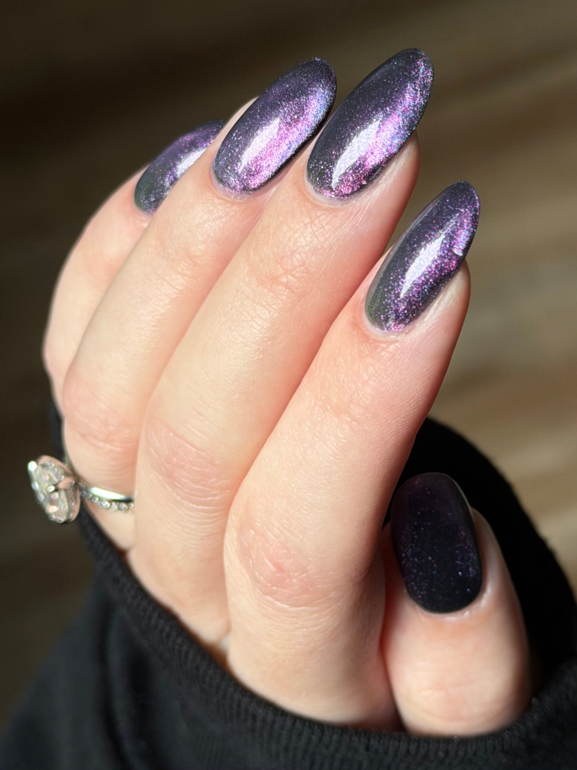 Lavender Menace by Glitch Lacquer, black jelly, purple-blue magnetic cat-eye, purple sparkle, on light skin tone almond nails