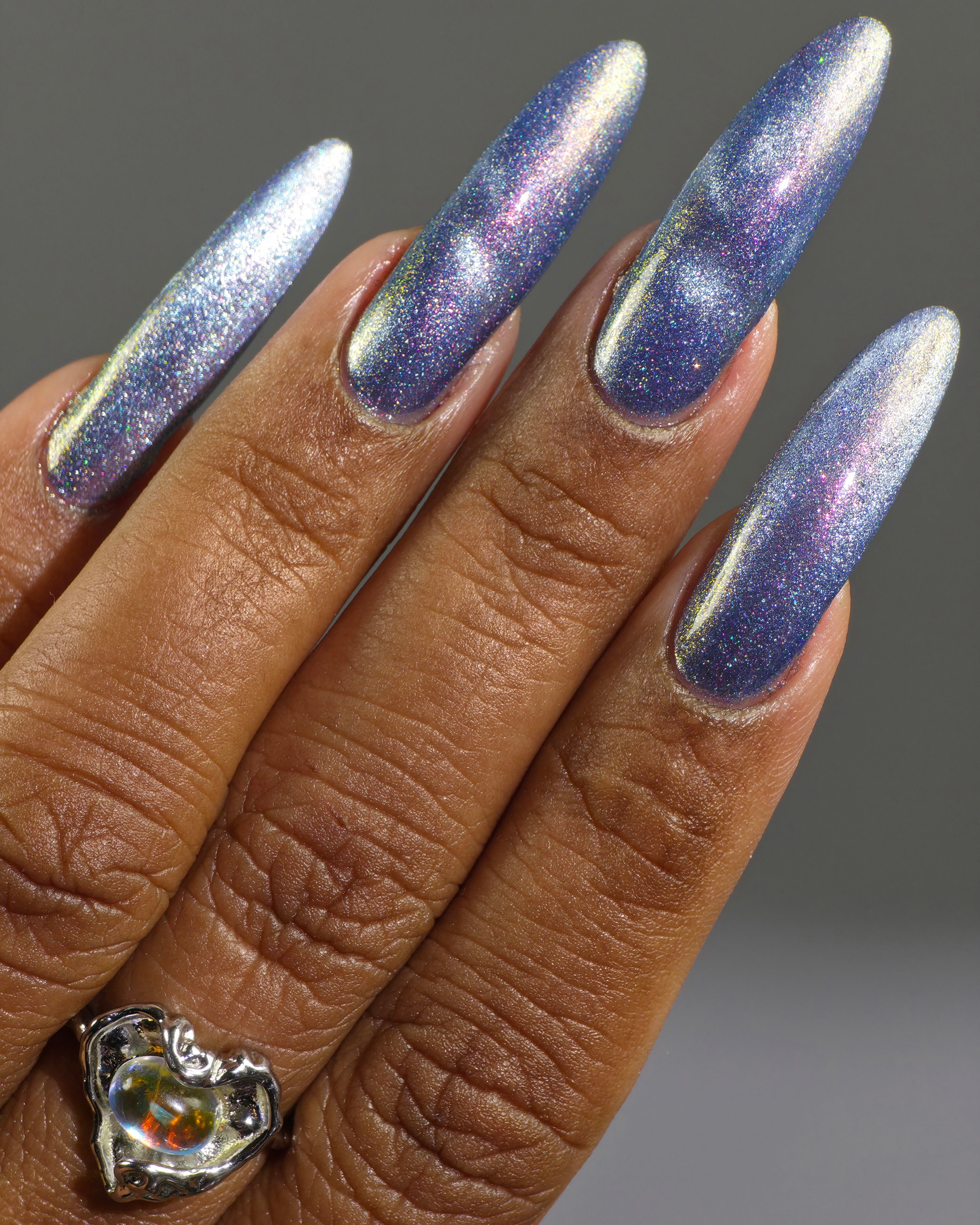 Protect the Dolls by Glitch Lacquer, blue jelly, silver magnetic cat-eye, color-shift shimmer, on medium-deep skin tone nails