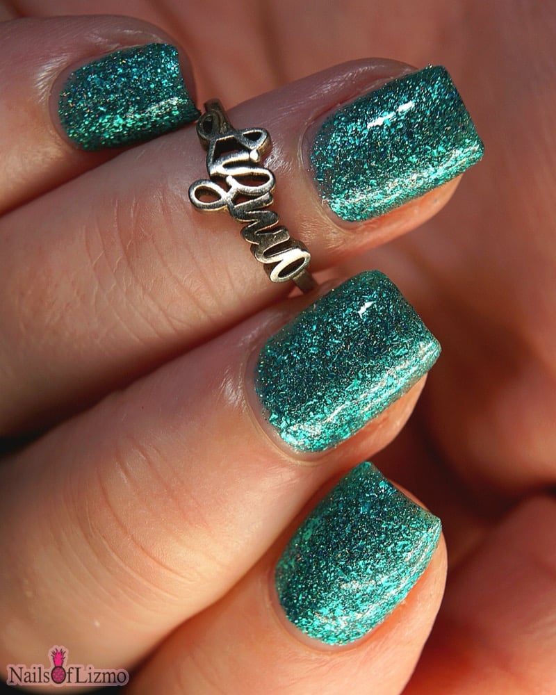 Mutant and Proud by Danglefoot Nail Polish, green-teal holographic reflective glitter flakie on a light-medium skin tone hand