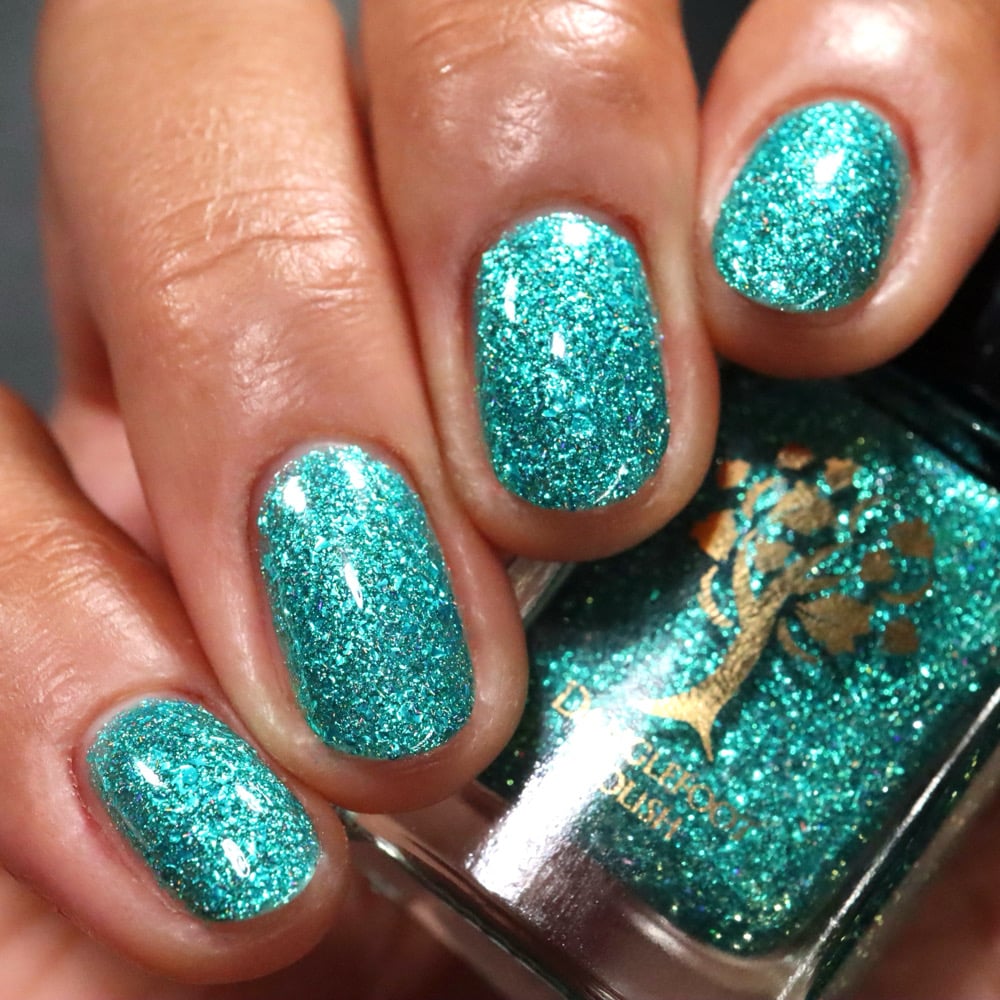 Mutant and Proud by Danglefoot Nail Polish, green-teal holographic reflective glitter flakie on a medium skin tone hand