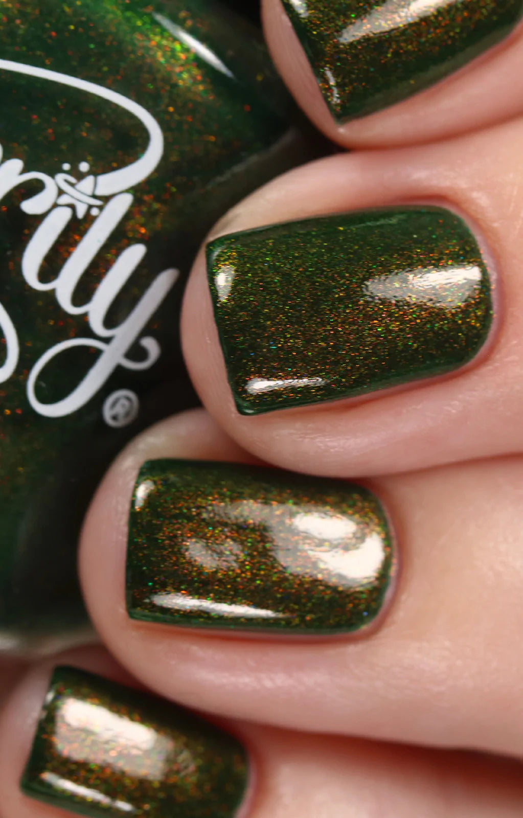 Artemis by Starrily, forest green with dense microflake shimmer shifting from warm copper to gold-green, glossy topcoat applied, on a light skin tone hand