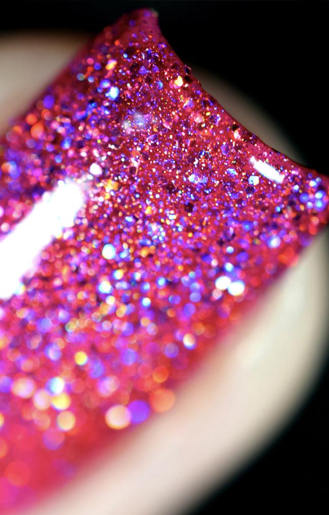 High Maintenance by Starrily, macro close-up of densely packed hot pink holographic glitter showing violet-to-orange prismatic spectrum flash