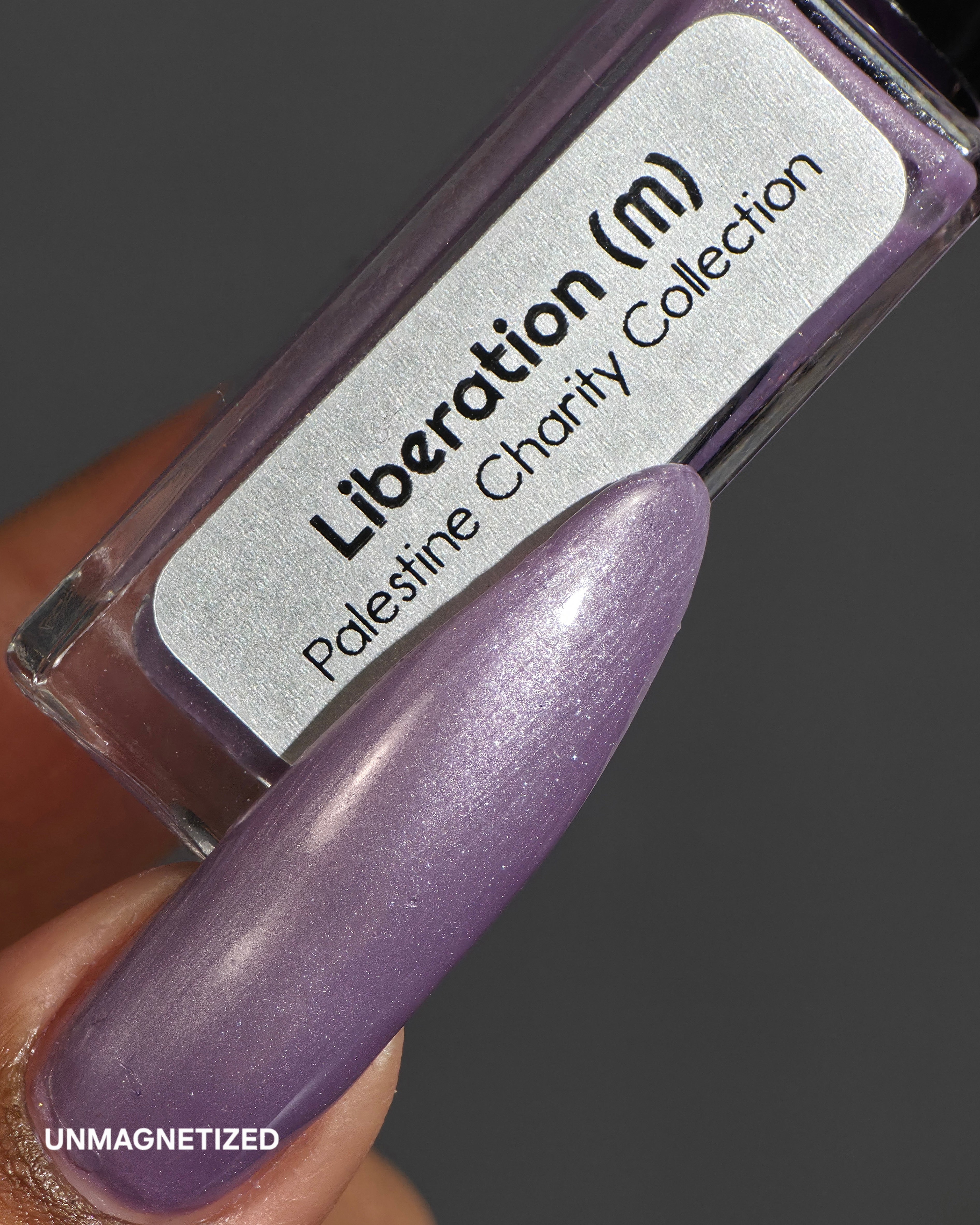 Liberation by Glitch Lacquer, lavender silver magnetic bottle with stiletto swatch on deep skin tone