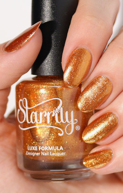 Pi Day Gift Set (Limited Edition) by Starrily, burnt amber-copper base with foil-like gold micro-glitter shimmer, bottle held in a light skin tone hand
