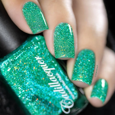 Blausee by Cadillacquer, teal green crelly with light teal reflective micro-glitter and yellow-gold iridescent flakes, bottle held in a light-medium hand