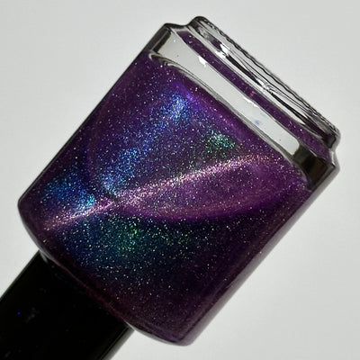 Moonlight Mist by Dam Nail Polish, deep purple magnetic showing teal-green and blue-violet magnetic shift patterns with holographic dust, bottle standalone product shot