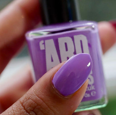 Dusk by 'Ard As Nails, vibrant medium purple creme with a slight blue-violet lean, bottle held in a medium hand
