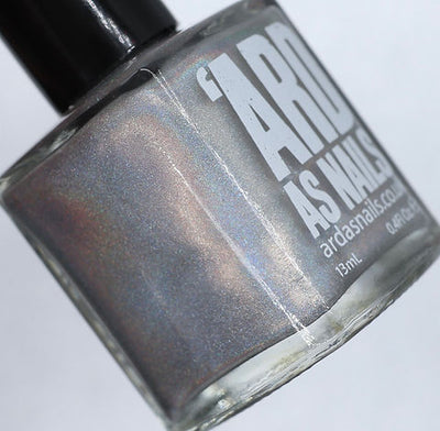 Cosmic by 'Ard As Nails, silver linear holo showing rose, bronze, and blue-violet spectral scatter, bottle standalone product shot