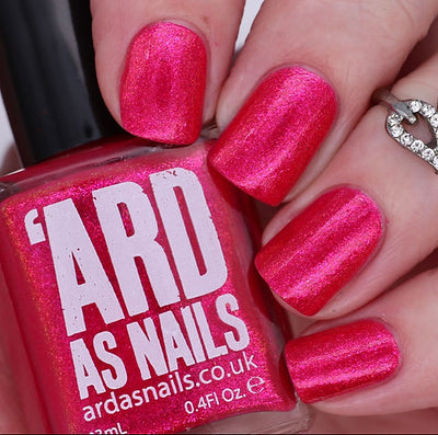 Beach Towel by 'Ard As Nails, hot pink-red shimmer with bright magenta pearl shimmer highlight, bottle held in a light skin tone hand