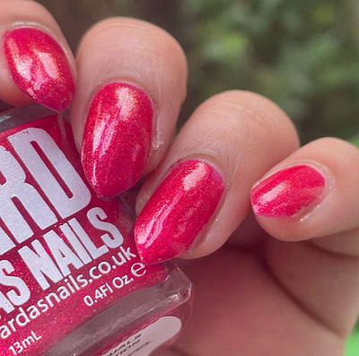 Beach Towel by 'Ard As Nails, bright crimson red shimmer showing red-to-gold shift in bright daylight, on a light skin tone hand