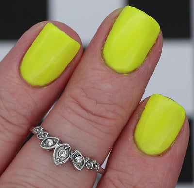 Lightning Speed by 'Ard As Nails, neon yellow-green creme, fully opaque on short square nails against checkered background, on a light skin tone hand