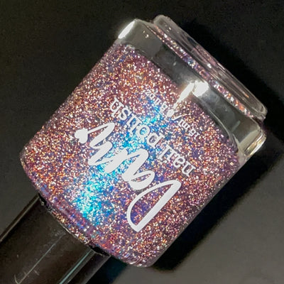 Robots Don't Poop by Dam Nail Polish, dusty mauve-purple base with teal-blue multichrome shimmer shift and dense silver reflective glitter under direct flash, bottle standalone product shot