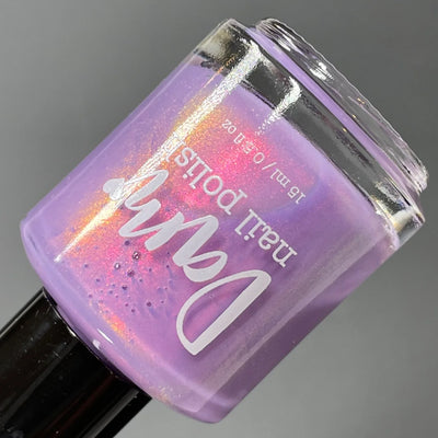 Winter Wisteria by Dam Nail Polish, soft lavender shimmer showing pink-to-orange-to-gold shift, bottle standalone product shot