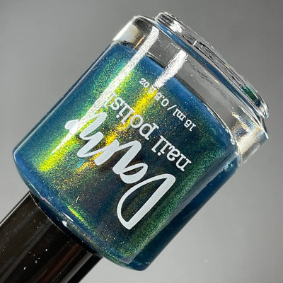 Moody Modern by Dam Nail Polish, deep navy base with gold-to-green color-shifting shimmer, showing full shift range, bottle standalone product shot