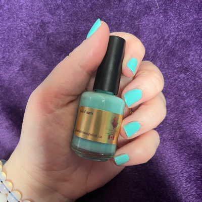 Sea Foam by Prairie Crocus Polish, vibrant aqua teal creme, bottle held in a light skin tone hand