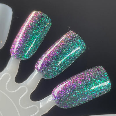 Permit to Hermit by Dam Nail Polish, teal-to-pink-purple multichrome flakies with bright green reflective glitter under direct flash, swatch stick