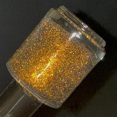 Champagne Sparkles by Dam Nail Polish, deep black jelly packed with warm bronze shimmer and bright gold reflective micro-glitter under direct flash, bottle standalone product shot