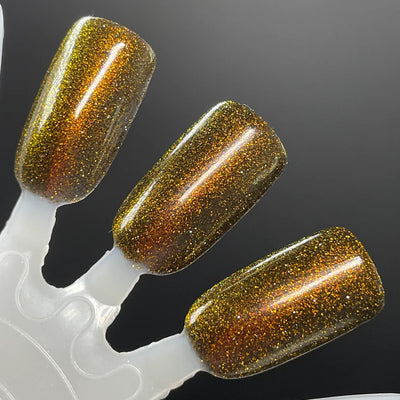 Champagne Sparkles by Dam Nail Polish, deep amber-black jelly with bronze-gold reflective glitter shifting warm copper under direct flash, swatch stick