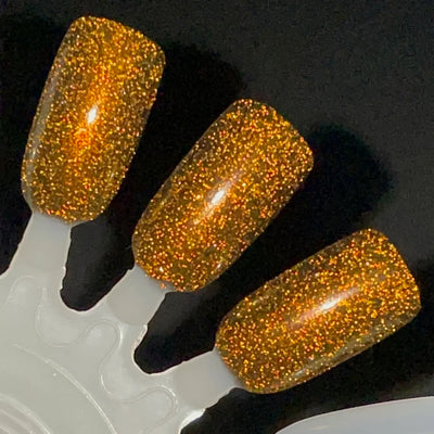 Champagne Sparkles by Dam Nail Polish, black-gold reflective shimmer glitter showing multidimensional amber-gold to orange flash under direct flash, swatch stick