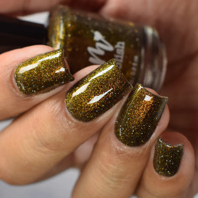 Champagne Sparkles by Dam Nail Polish, deep olive-black jelly with bronze-gold shimmer and gold reflective microglitter under direct flash, on a light-medium skin tone hand