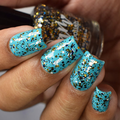 Kintsugi by Dam Nail Polish, black-blue glitter topper with dense gold, dark navy, and white multi-size hex glitters over turquoise creme, on a medium skin tone hand