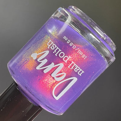 Roe, Roe, Roe Your Vote by Dam Nail Polish, blue-leaning purple base with red-to-gold-to-green multichrome shimmer pooling dramatically at bottle center, bottle standalone product shot