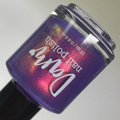 Roe, Roe, Roe Your Vote by Dam Nail Polish, blue-leaning purple multichrome shimmer with scattered red-to-gold shift visible across bottle, bottle standalone product shot