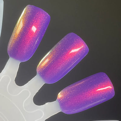 Roe, Roe, Roe Your Vote by Dam Nail Polish, blue-leaning purple jelly base with red-orange to gold multichrome shimmer intensifying at highlight zones, swatch stick