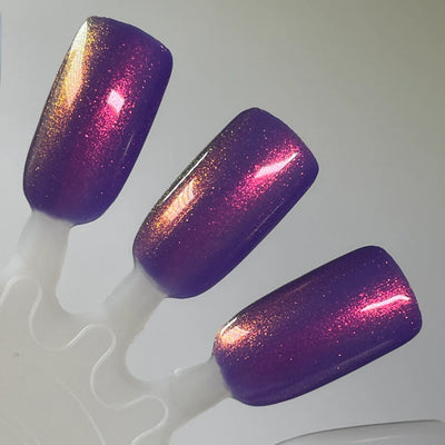 Roe, Roe, Roe Your Vote by Dam Nail Polish, deep blue-leaning purple with red-pink and gold microflake multichrome shimmer showing full shift range, swatch stick