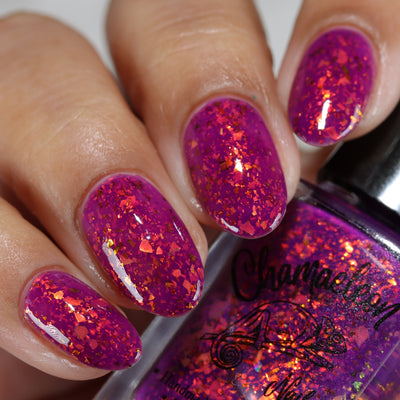 Evening in Provence by Chamaeleon Nails, magenta jelly with dense orange-to-gold multichrome flakies, on a light-medium skin tone hand