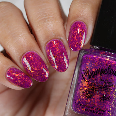 Evening in Provence by Chamaeleon Nails, magenta-pink jelly showing orange-to-gold and copper-to-green UCC flakie shifts, on a light-medium skin tone hand
