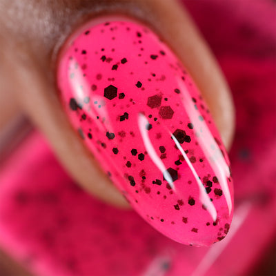 The Night's a Brighter Shade by Cadillacquer, macro close-up of neon hot pink base with matte black and dark burgundy hex glitter in mixed sizes