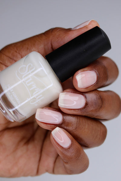 Ghost Jelly by Starrily, sheer white jelly with translucent blush-pink tint, bottle held in a deep skin tone hand