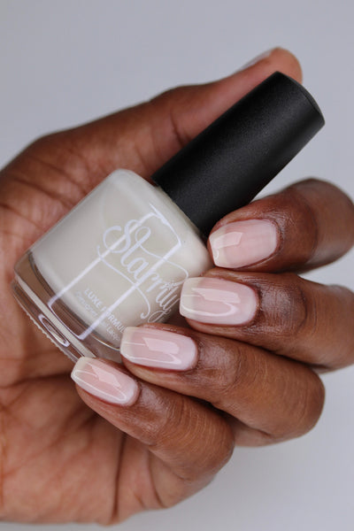 Ghost Jelly by Starrily, translucent milky blush-white jelly over deep skin tone, bottle held in a deep skin tone hand