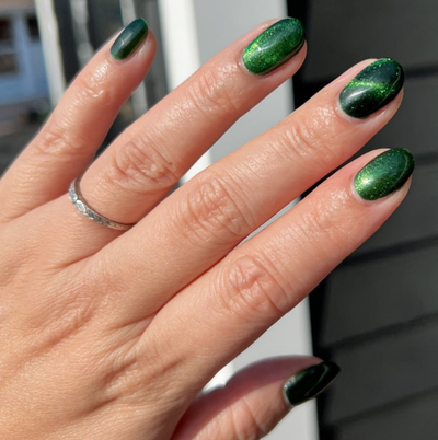 New Divide by Danglefoot Nail Polish, green shimmer jelly magnetic on a light skin tone hand