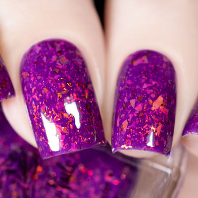 Evening in Provence by Chamaeleon Nails, purple-violet jelly showing copper, magenta, and orange UCC flakie shifts under studio light, on a light skin tone hand