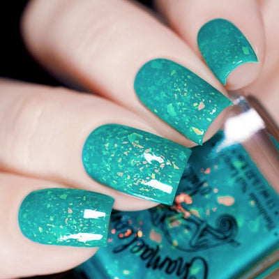 Kuang Si Falls by Chamaeleon Nails, bright teal neon jelly with large orange-gold iridescent flakies, on a light skin tone hand