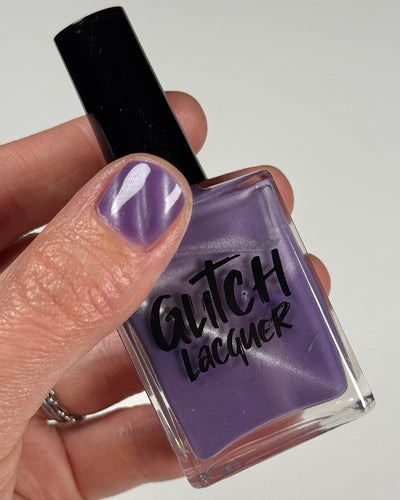 Liberation by Glitch Lacquer, lavender silver magnetic bottle in hand, light-medium skin tone