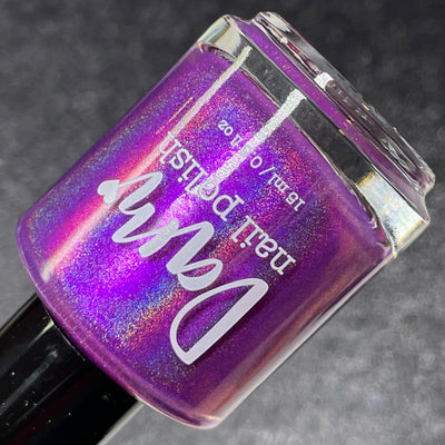 Sleigh My Name, Sleigh My Name by Dam Nail Polish, violet-purple holographic duochrome shimmer with pink-purple shift and rainbow scatter, bottle standalone product shot