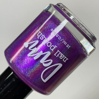 Sleigh My Name, Sleigh My Name by Dam Nail Polish, medium-deep purple with strong linear holographic scatter and electric pink-purple shimmer shift under direct flash, bottle standalone product shot