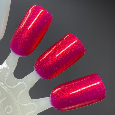 Cup of Cheer by Dam Nail Polish, crimson red shimmer with warm pink lean and glowing orange-red shift, swatch stick