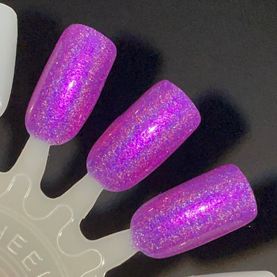 Sleigh My Name, Sleigh My Name by Dam Nail Polish, violet-purple with dense pink-to-purple shifting shimmer and linear holographic scatter, showing jelly-like translucency under direct flash, swatch stick